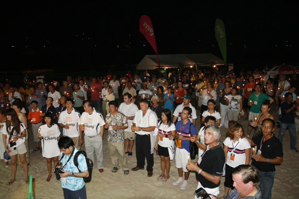 Phuket King's Cup 2008. The King's Cup crowd lights candles and wishes His Majesty ``Happy Birthday`` on the beach in front of Mom Tri's Boathouse. 

 photo copyright Guy Nowell http://www.guynowell.com taken at  and featuring the  class