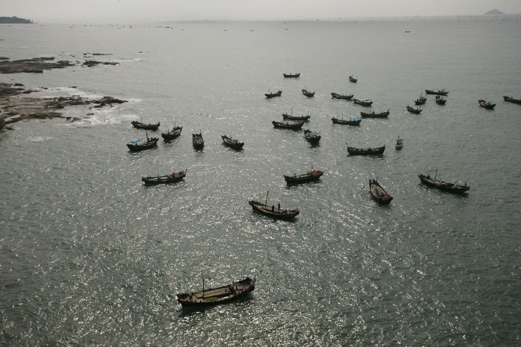 A flotilla of weed-collecting boats working close inshore before racing starts on Day 4. photo copyright Guy Nowell http://www.guynowell.com taken at  and featuring the  class