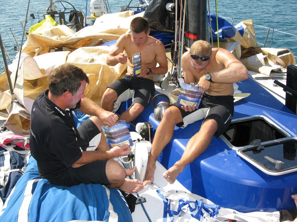 Team Delta Lloyd taking shelter in Salomique Bay, Philippines. The Crew is working hard to repair the ripped mainsail on deck. Tine for lunch on deck, (l-r) Stu Wilson, Morgan White, Gerd-Jan Poortman © Sander Pluijm/Team Delta Lloyd/ Volvo Ocean Race http://www.volvooceanrace.org