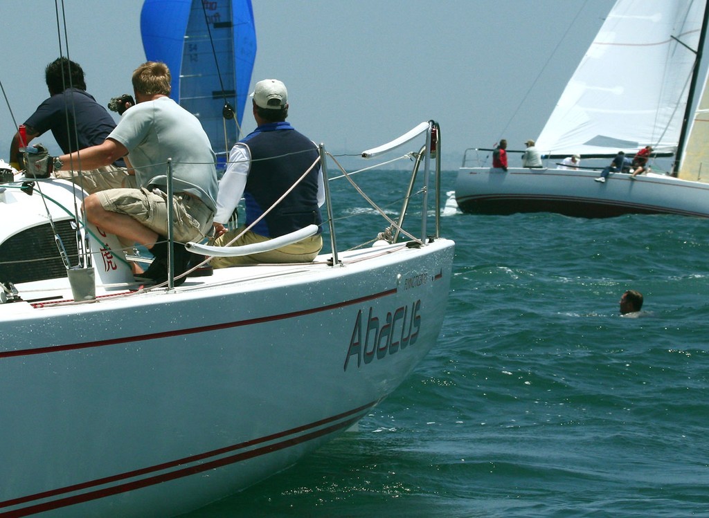 Unidentified crewman (r.) bobs in water after falling off Abacus - Acura presents Ullman Sails Long Beach Race Week / Day 2 © Rich Roberts http://www.UnderTheSunPhotos.com