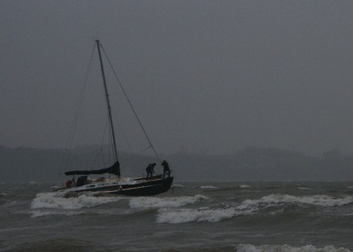 Trimaran Galavante with wetsuit clad salvage crew aboard- dragged right across a reef - Algies Bay, 26 July 2008 © Ross Walker