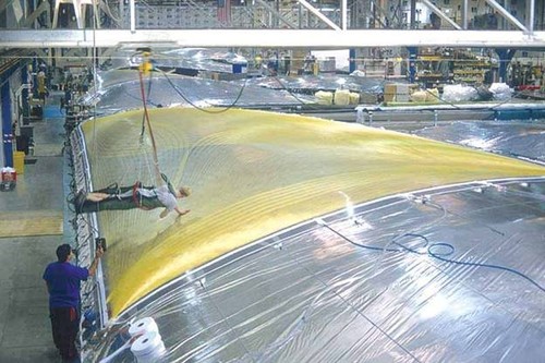 Once the yarns are laid, a second film is positioned on top of the base film and yarn, tensioned, and then covered with a large vacuum bag that compresses the laminate at approximately 1,800 pounds per square foot. © North Sails http://www.northsails.com/