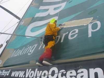Crewman up on the boom repair a rip in the mainsail on Volvo Open 70 ABN AMRO TWO Leg 4 ©Simon Fisher  © Volvo Ocean Race http://www.volvooceanrace.com