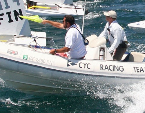 On the Water Judges indicate an infringement of RRS 42 by pointing at the infringing boat with a yellow flag and making a sound signal. © Rich Roberts http://www.UnderTheSunPhotos.com