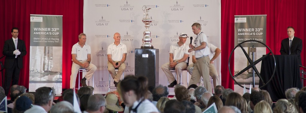 America’s Cup in Newport<br />
Sail Newport’s America’s Cup Luncheon. BMW Oracle Team members, Tom Ehmann MC and the port steering wheel of USA 17 which was presented to President Obama. © Daniel Forster http://www.DanielForster.com