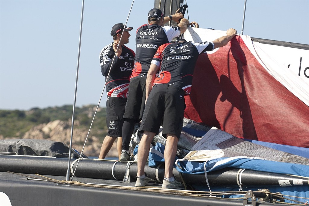 Emirates Team New Zealand sailors  remove the main sail after the wind died out and racing was abandoned. Day two of the Louis Vuitton Trophy, La Maddalena. Sardinia, Italy. 23/5/2010 © Chris Cameron/ETNZ http://www.chriscameron.co.nz