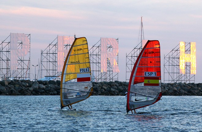 The current world Champions in the Men’s and Women’s RS:X, Piotr Myszka of Poland and Blanca Manchon of Spain arrive at Bathers Beach carrying the ISAF World Championships Flag to be raised to officially open the 2011 ISAF Sailing World Championships on December 2, 2011 in Perth, Australia. © Paul Kane /Perth 2011 http://www.perth2011.com