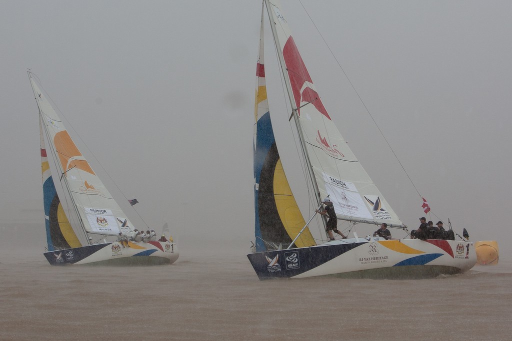 Jesper Radich emerges from the gloom with Peter Gilmour to leeward on day 1 at the Monsoon Cup 2011. Kuala Terengannu, Malaysia. 23 November 2011.  &copy; Gareth Cooke/Subzero Images/ Monsoon Cup - copyright http://www.monsooncup.com.my