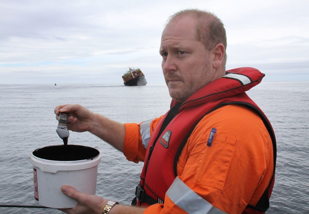 Salvage expert Drew Shannon with a sample of the thick black fuel oil from the Rena. © Maritime NZ www.maritimenz.govt.nz