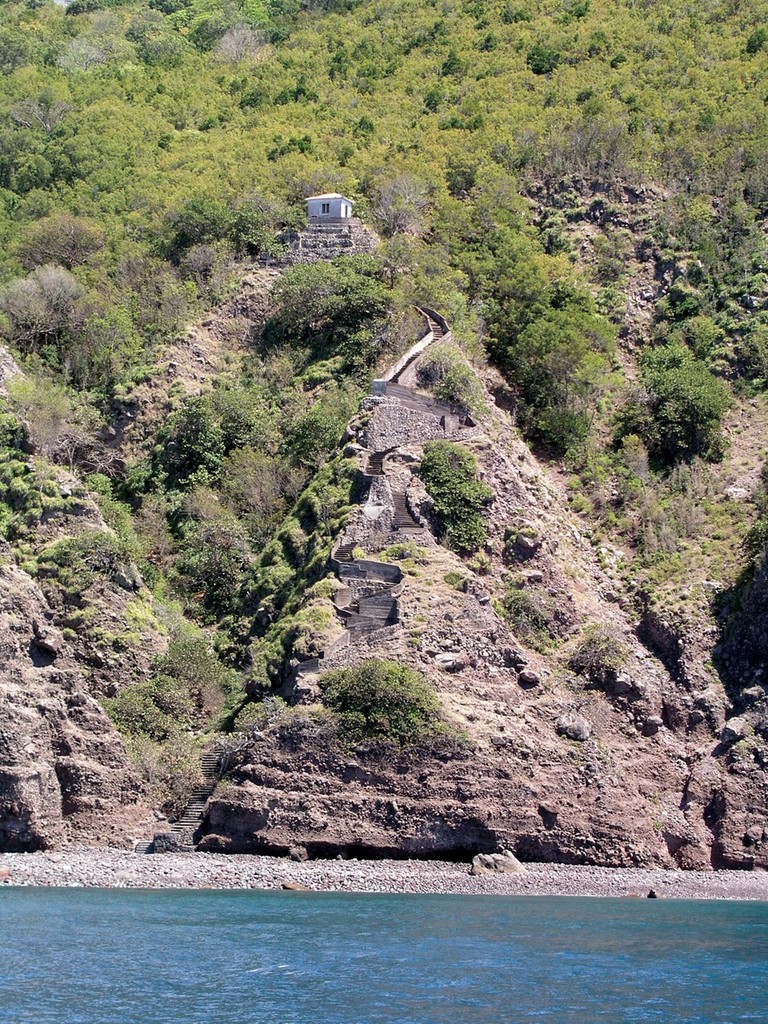 The Ladder. This is an 800-step stairway leading from the small rocky beach at Ladder Bay to the top of the island of Saba. Before the small harbour at Fort Bay was built, The Ladder was the only way to get goods and people to the villages at the top of the island. Male and female porters with great strength and pride carried food, furniture and even a Bishop up The Ladder. The little building is an old customs warehouse and is about two-thirds of the way to the top. © Canadian Yachting (SWCC)