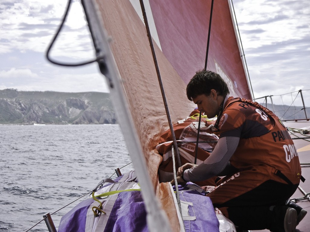 Bowman Mike Pammenter stacking sails as Camper with Emirates Team New Zealand work their way along the South African coast during leg 2 of the Volvo Ocean Race 2011-12, from Cape Town, South Africa to Abu Dhabi, UAE.  © Hamish Hooper/Camper ETNZ/Volvo Ocean Race