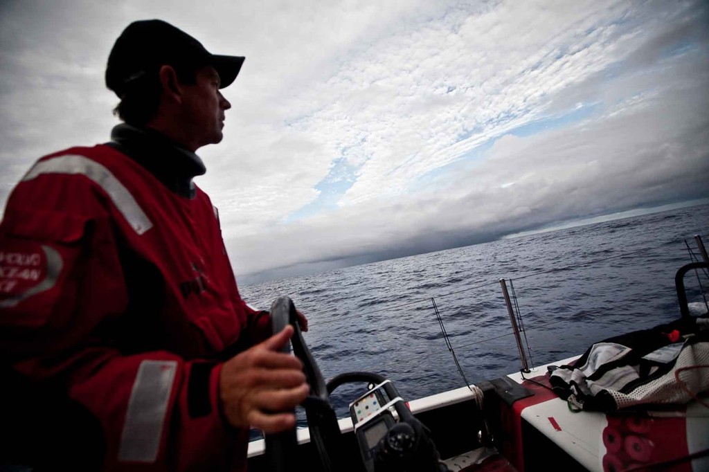 Brad Jackson has two hands on the helm and two eyes on the horizon, where an ominous black cloud looms in the waiting. PUMA Ocean Racing powered by BERG during leg 4 of the Volvo Ocean Race 2011-12  © Amory Ross/Puma Ocean Racing/Volvo Ocean Race http://www.puma.com/sailing