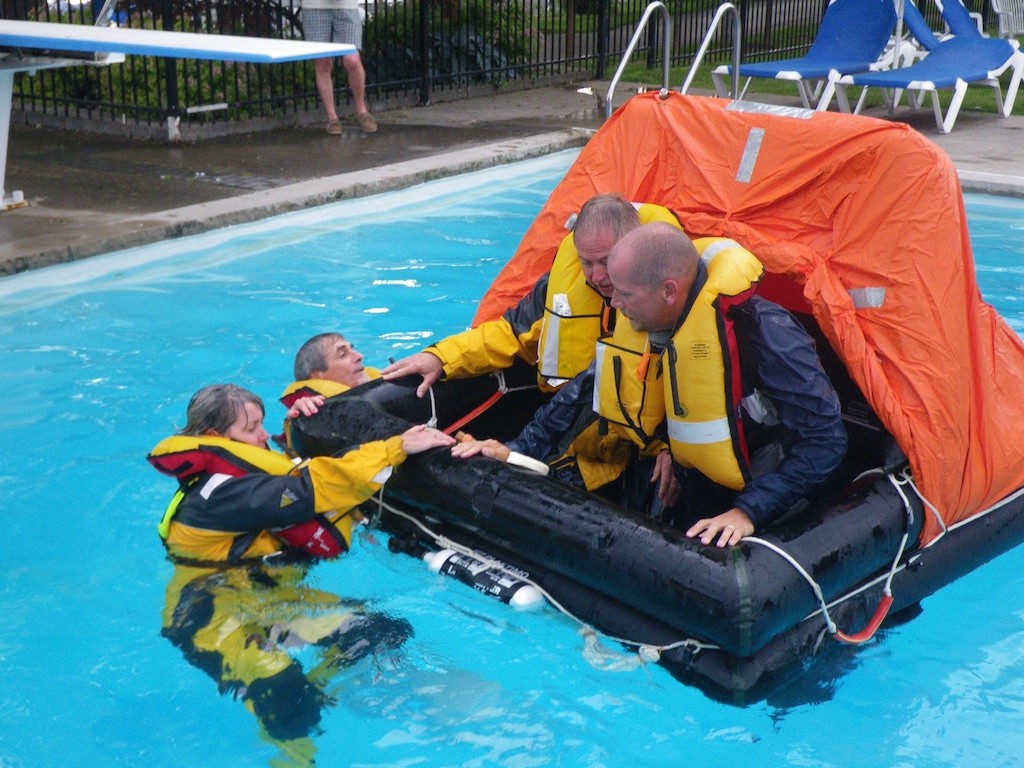 Participants help each others boarding a four-person liferaft © Guy Perrin http://sail-world.com
