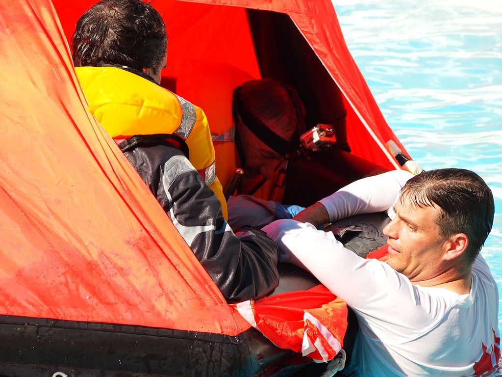 Instructor Eric Hill gets in the water to explain the best way for six people to keep a liferaft balanced photo copyright Greg Nicoll taken at  and featuring the  class