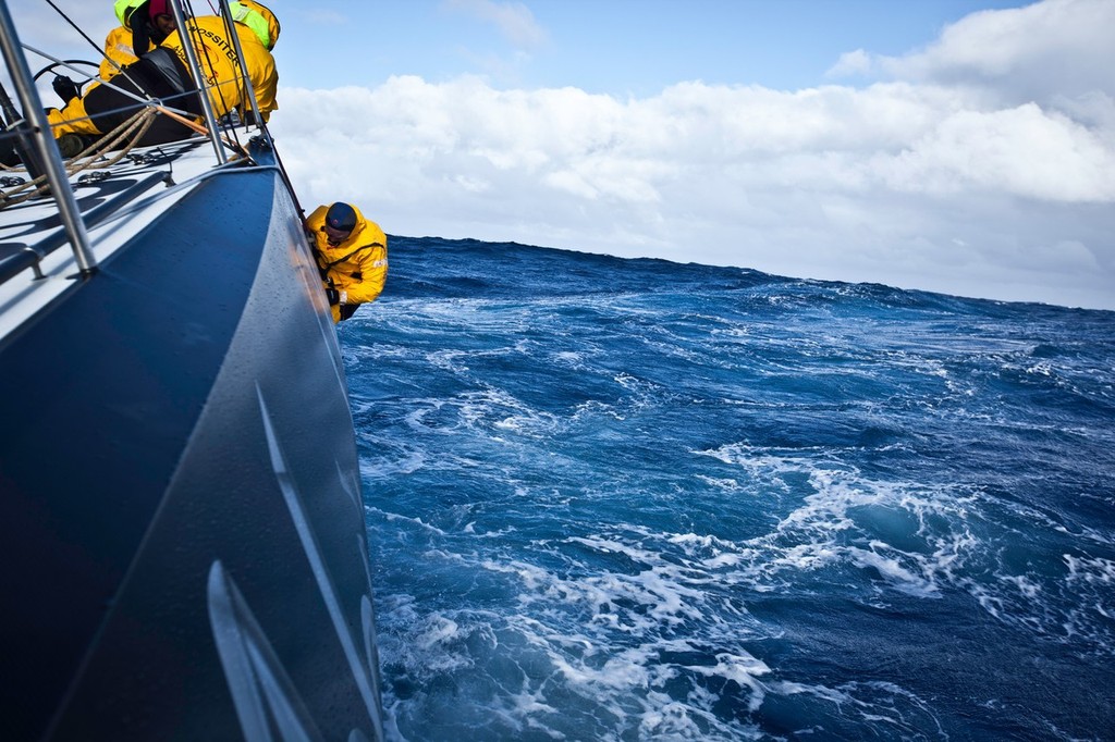 Justin Slattery is lowered over the side of Abu Dhabi Ocean Racing to fix delamination damage, sustained during leg 5 of the Volvo Ocean Race 2011-12, from Auckland, New Zealand to Itajai, Brazil.  © Nick Dana/Abu Dhabi Ocean Racing /Volvo Ocean Race http://www.volvooceanrace.org