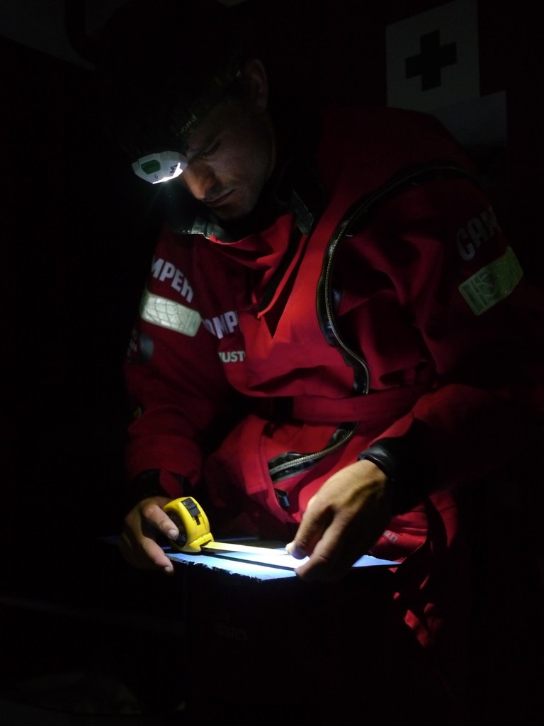 Mike Pammenter measures up some carbon fibre plates for repairing the forward bulkhead onboard CAMPER with Emirates Team New Zealand during leg 5 of the Volvo Ocean Race 2011-12, from Auckland, New Zealand to Itajai, Brazil. (Credit: Hamish Hooper/CAMPER ETNZ/Volvo Ocean Race) photo copyright Hamish Hooper/Camper ETNZ/Volvo Ocean Race taken at  and featuring the  class