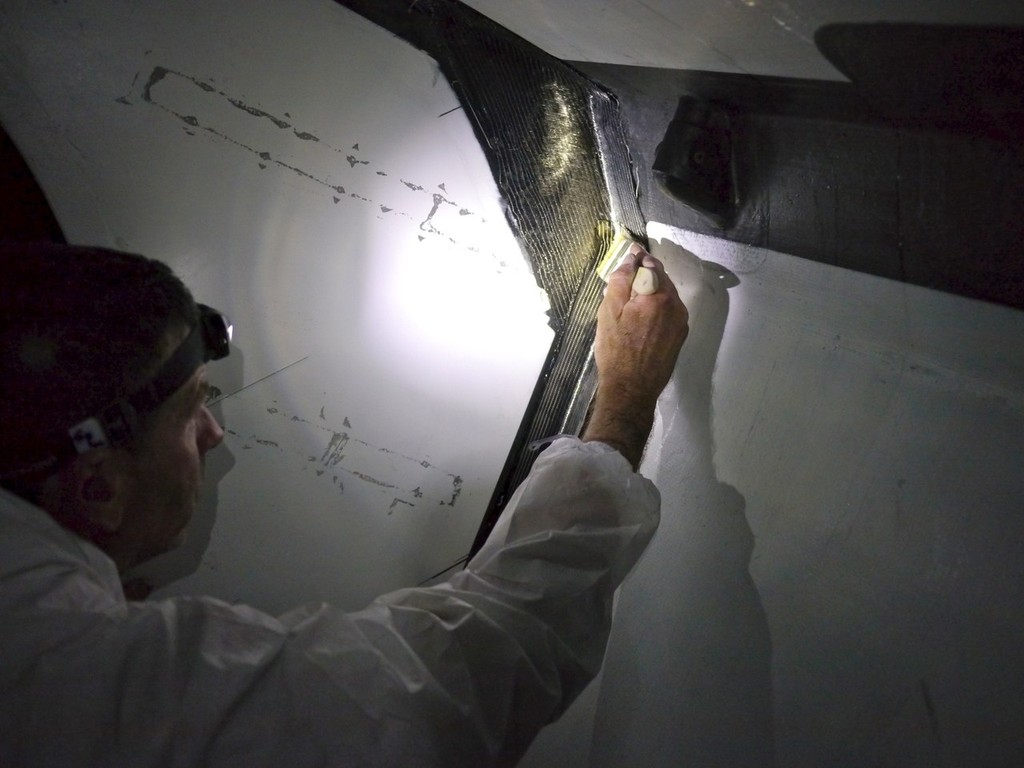 Rob Salthouse applying resin to the carbon cloth on the damaged forward bulkhead onboard Camper with Emirates Team New Zealand during leg 5 of the Volvo Ocean Race 2011-12, from Auckland, New Zealand to Itajai, Brazil. © Hamish Hooper/Camper ETNZ/Volvo Ocean Race