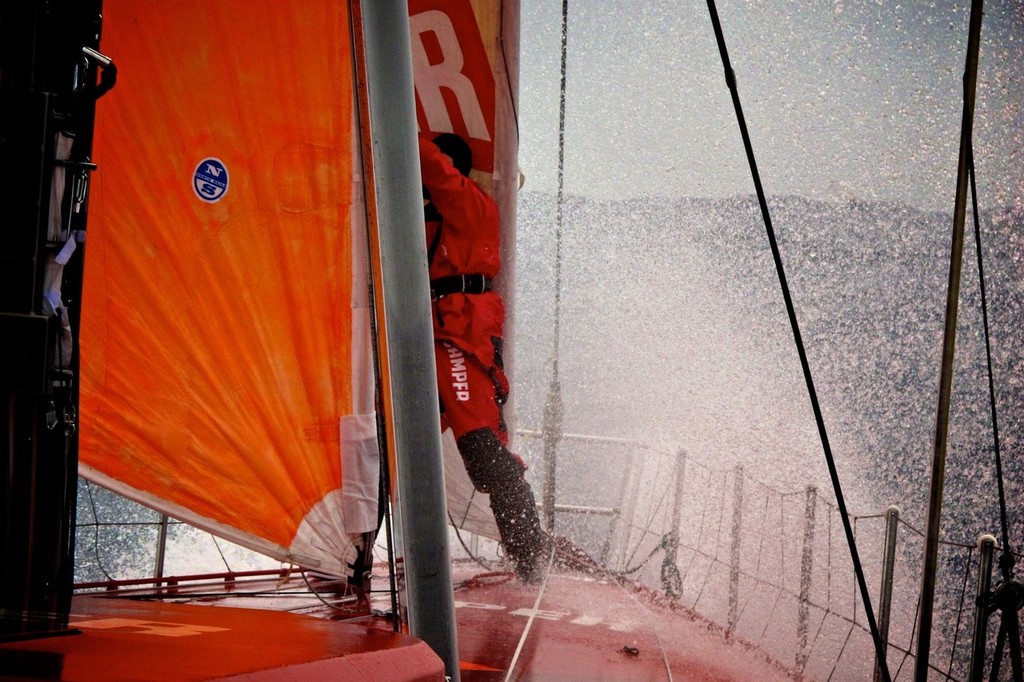 Daryl Wislang doing a quick repair on the foredeck being showered in icy ocean water onboard CAMPER with Emirates Team New Zealand during leg 5 of the Volvo Ocean Race 2011-12, from Auckland, New Zealand to Itajai, Brazil.  © Hamish Hooper/Camper ETNZ/Volvo Ocean Race