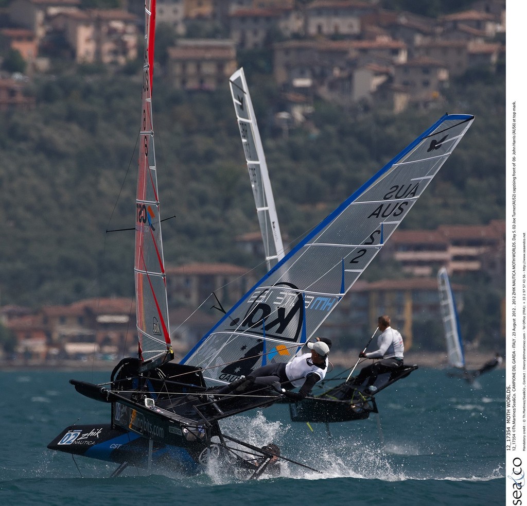 12_17354  ©Th.Martinez/Sea&Co.  CAMPIONE DEL GARDA - ITALY . 23 August  2012 . 
2012 ZHIK NAUTICA MOTH WORLDS. Day 5.
02-Joe Turner(AUS2) capzising front of  06- John Harris (AUS6) at top mark. photo copyright Th Martinez.com http://www.thmartinez.com taken at  and featuring the  class