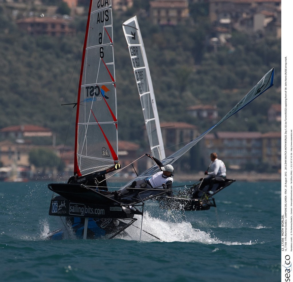 12_17356  ©Th.Martinez/Sea&Co.  CAMPIONE DEL GARDA - ITALY . 23 August  2012 . 
2012 ZHIK NAUTICA MOTH WORLDS. Day 5.
02-Joe Turner(AUS2) capzising front of  06- John Harris (AUS6) at top mark. photo copyright Th Martinez.com http://www.thmartinez.com taken at  and featuring the  class