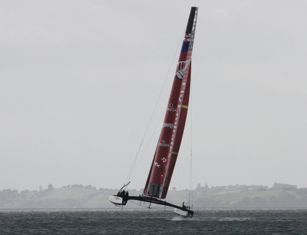 Emirates Team NZ’s AC72  off Takapuna Beach on foils in a gust. This photo indicates how far forward the apparent wind is on an AC72. The wind in this shot is blowing from the southwest and the AC72 is sailing on a NE course © Richard Gladwell www.photosport.co.nz