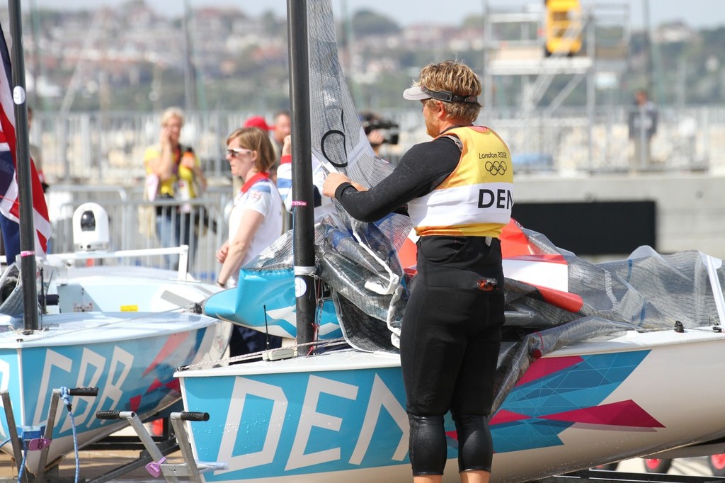  August 5, 2012 - Weymouth, England - Silver medalist, Jonas Hogh-Christensen Lowers his Finn class mainsail for the last time photo copyright Richard Gladwell www.photosport.co.nz taken at  and featuring the  class