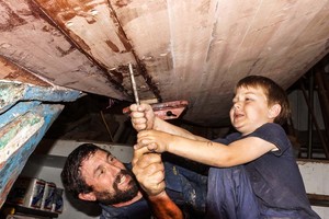 CF and his son Billy screw the last plank into C.F. Koehler's 1928 10-meter Sally has been relaunched following a two year reconstruction from the keel up of this classic thoroughbred. All new Honduras mahogany planking and alternating steam bent oak  with cold-formed steel angles make up the frames. Sally was one of 14 10-meters built at the Abeking and Rasmussen yard in Bremen, Germany. Photo credit must read:  Bob Grieser/OUTSIDEIMAGES.COM Outside Images Photo Agency photo copyright Bob Grieser/Outside Images www.outsideimages.com taken at  and featuring the  class