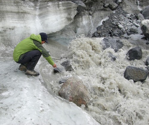 Field assistant Ben Gready measures the electrical conductivity of the ‘N’ glacier outflow. By making this measurement at different times of the season, scientists can compare concentrations of dissolved nutrients in meltwater passing through the subglacial environment. Early in the melt season, the network of tunnels and chasms under the glacier is less efficient at draining meltwater, extending the meltwater’s contact with sediments and bedrock, thus picking up more dissolved nutrients. © Matt Charette, WHOI http://www.whoi.edu/