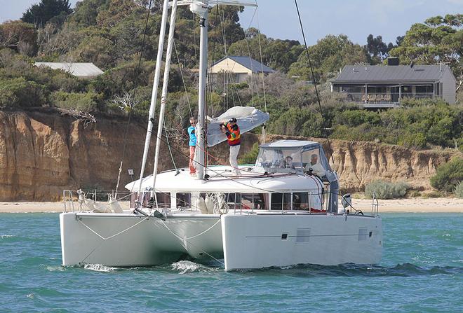 Brendan Hunt at the mast for the launching of SKI’s mainsail. - 2013 Lagoon Escapade ©  John Curnow
