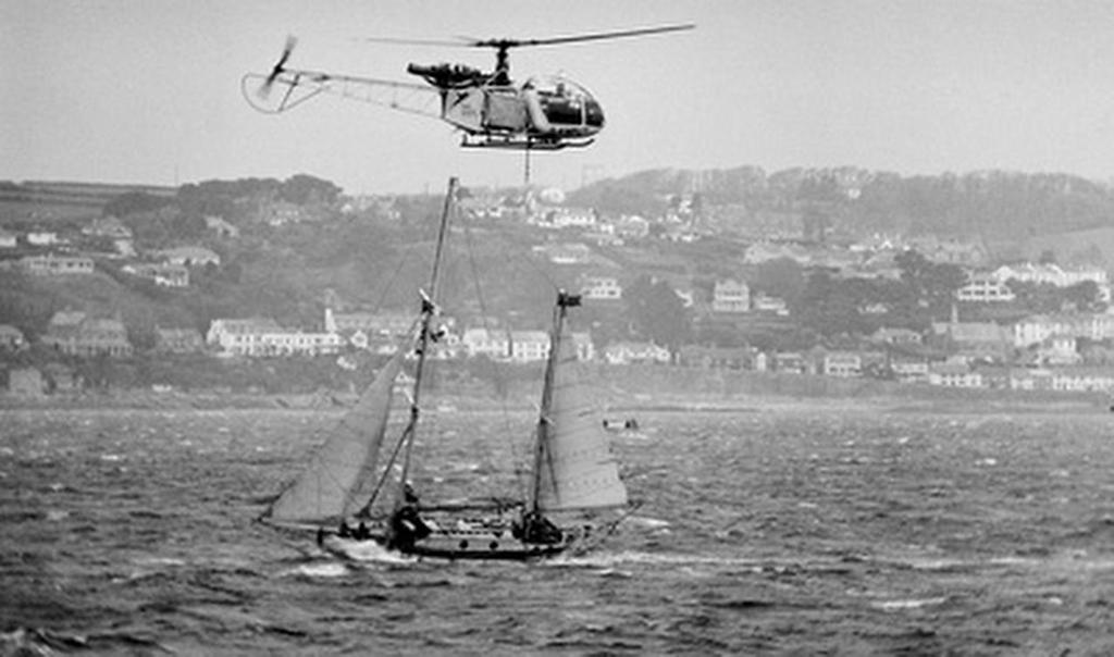 Circa 22nd April 1969: a TV helicopter hovers  overhead as Robin Knox-Johnston sails his 32ft yacht SUHAILI off Falmouth, England after becoming the first man to sail solo non-stop around the globe. Knox-Johnston was the sole finisher in the Sunday Times Golden Globe solo round the world race, having set out from Falmouth, England on 14th June 1968 © Bill Rowntree - PPL http://www.pplmedia.com