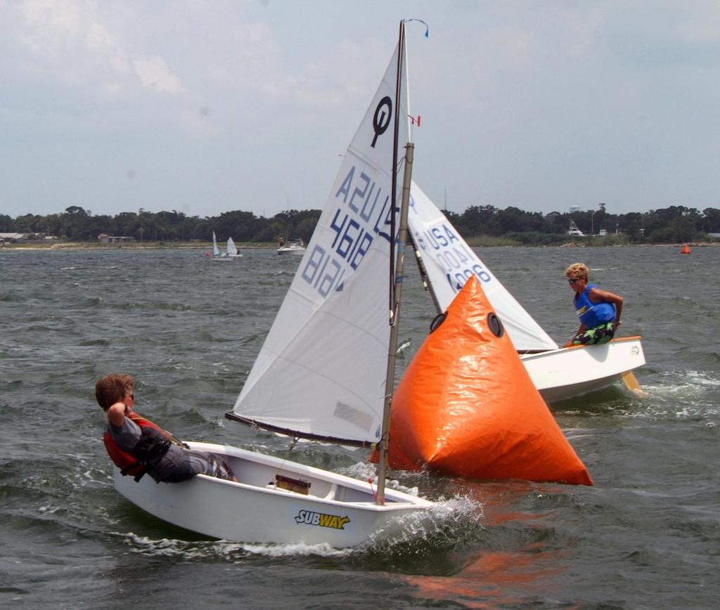 A close mark rounding in last summer's US Sailing Junior Olympics Sailing Festival hosted by Pensacola Yacht Club. In 2013 PYC will not only host the Junior Olympics July 5-7 but will also host the US Optimist Dinghy Assn SE Championship which is a qualifer for the National Championship. Over 200 young competitors and their coaches and/or families are expected for the Sept 20-22 championship. The Junior Olympics usually has around 110 entries in multiple classes of boats. 
Photo Credit Â©Talbot W photo copyright Talbot Wilson taken at  and featuring the  class