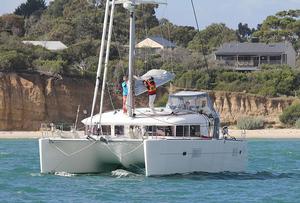 Brendan Hunt at the mast for the launching of SKI’s mainsail. - 2013 Lagoon Escapade photo copyright  John Curnow taken at  and featuring the  class