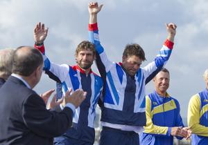 Iain Percy (left) and Andrew Simpson (GBR), acknowledge the crowd at the medal ceremony for the Men&rsquo;s Keelboat (Star) event in The London 2012 Olympic Sailing Competition. photo copyright onEdition http://www.onEdition.com taken at  and featuring the  class