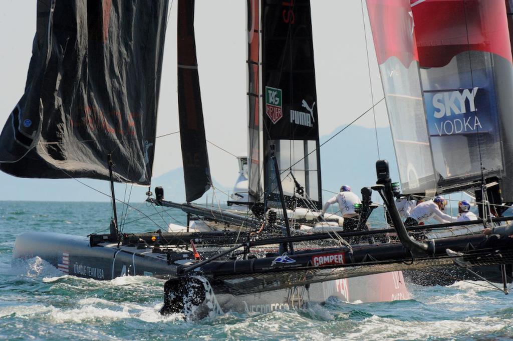 Oracle Team USA Slingsby works hard to hold the lead in the first race while Emirates Team New Zealand rides Slingsby's tail at the first windward gate rounding during the first race on the first day of racing at the ACWS in Naples Italy on April 17, 2013. photo copyright  SW taken at  and featuring the  class