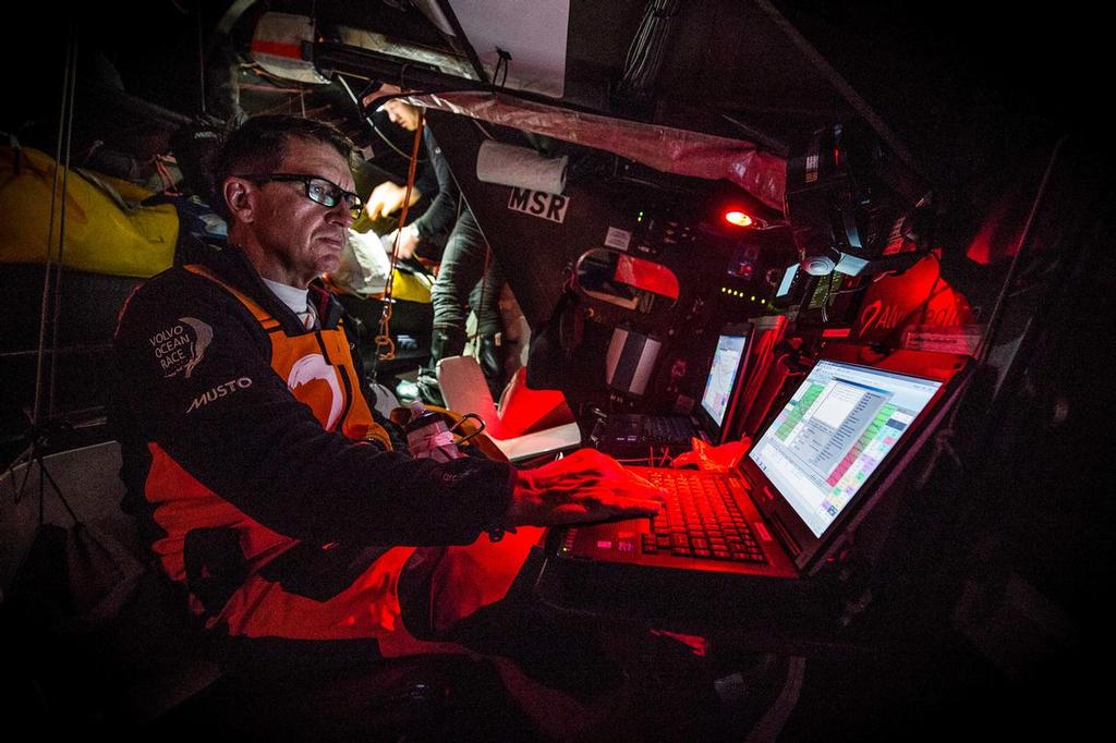 March 19, 2015. Leg 5 to Itajai onboard Team Alvimedica. Day 1. The still weakening Ex-Cylone Pam serves up a dosage of nastiness as the sea state continues to destabilize for the push to get east above it. Will Oxley in the nav station while Dave Swete looks for his dry suit in the stack behind. ©  Amory Ross / Team Alvimedica
