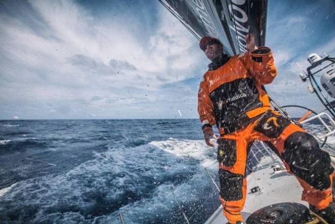 Seb Marsset peaks to leeward to critique the jib trim as spray shoots over the deck. - Leg six to Newport – Volvo Ocean Race 2015 ©  Amory Ross / Team Alvimedica