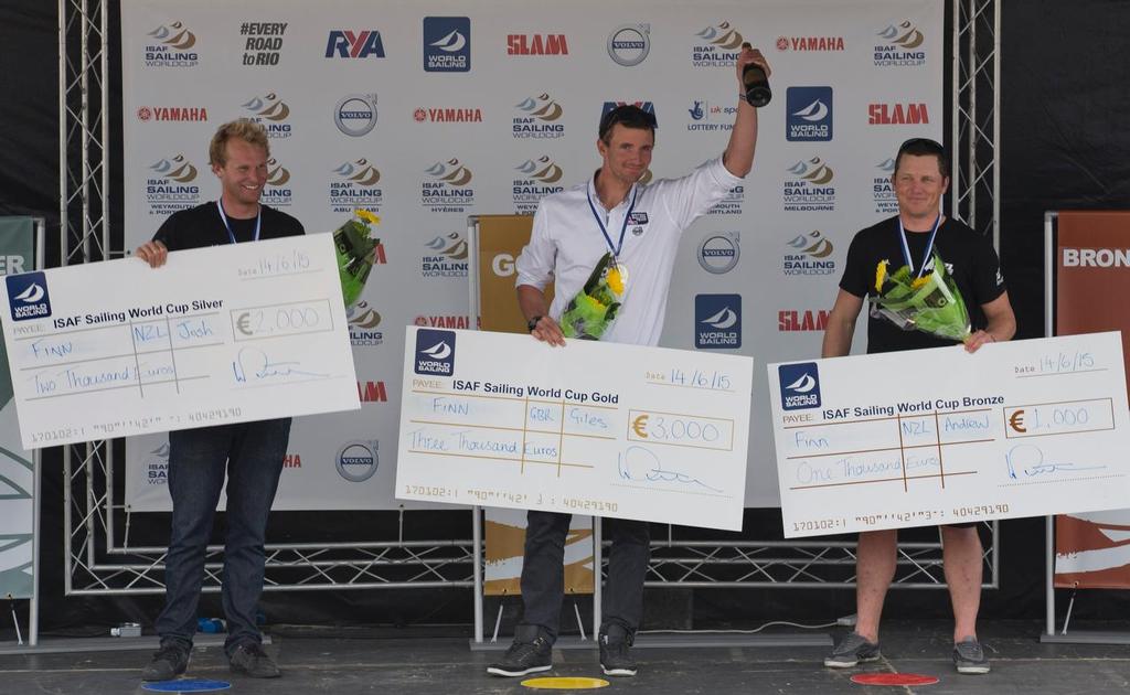 Kiwis Josh Junior, NZL, and Andrew Murdoch, NZL, flank winner Giles Scott, GBR  in the Mens One Person Dinghy Heavy (Finn) prize giving on day five of the ISAF Sailing World Cup Weymouth & Portland. © onEdition http://www.onEdition.com