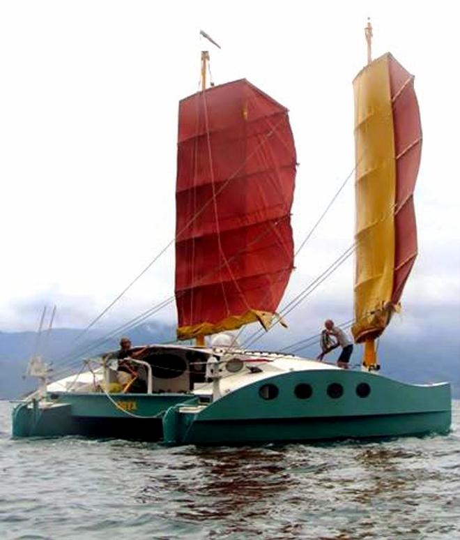 Oryx, like China Moon, carries a biplane junk rig and is seen here with Carly on the helm and Pete on deck © Pete Hill