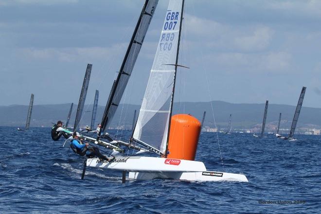 UK sailor Chris Field rounds the top mark, just ahead of barefoot Aussie Jason Waterhouse - 2015 A-Class Catamaran World Championships © Gordon Upton