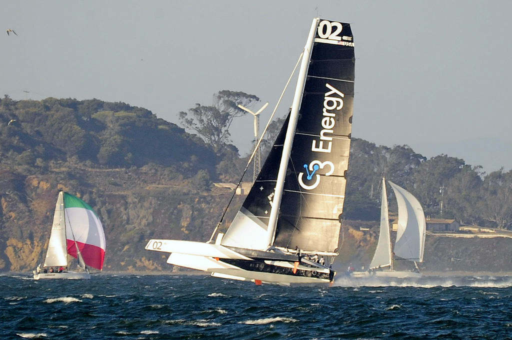 Tom Siebel's MOD70 trimaran Orion, scaring the hell out of a couple of monohulls, and probably themselves, when the wind amped-up late in the afternoon. FYI, the large propeller is an onshore wind generator and not a new secret weapon/accessory on the tri. photo copyright Chuck Lantz http://www.ChuckLantz.com taken at  and featuring the  class