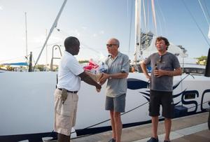 Gerald Bibot and Michel Kleinjans receive a basket of Grenada's finest goods with the compliments of Grenada Tourism  - 2015 RORC Transatlantic Race photo copyright Orlando Romain / RORC taken at  and featuring the  class