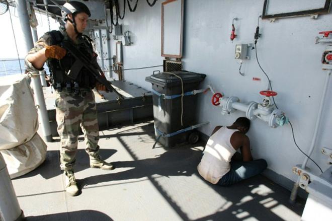 A French soldier guards a suspected Somali pirate on board the French warship 