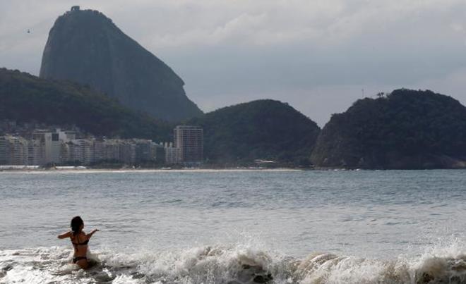 A woman is pictured with the Sugar Loaf mountain in background on Copacabana beach in Rio de Janeiro, Brazil, June 9, 2016. © Reuters / Sergio Moraes