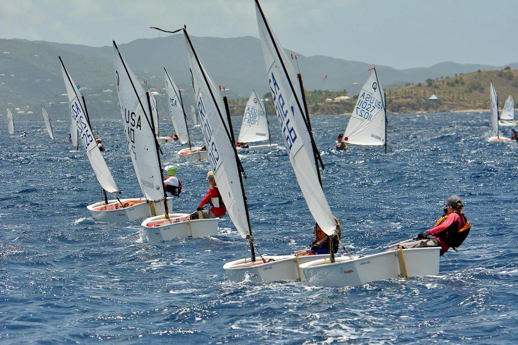 The Advanced Optimist Fleet sails downwind with St. Thomas in the background. Credit: Dean Barnes © Dean Barnes