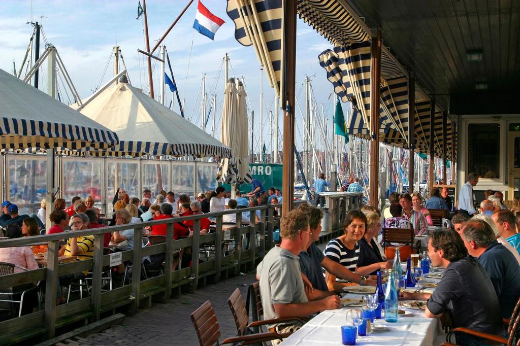Pepole enjoying their meals from the terraces along Scheveningen harbour; The Hague, Netherlands, base for Volvo Ocean Race Team AkzoNobel skippered by Simeon Tienpont - July 4, 2016 photo copyright Volvo Ocean Race http://www.volvooceanrace.com taken at  and featuring the  class