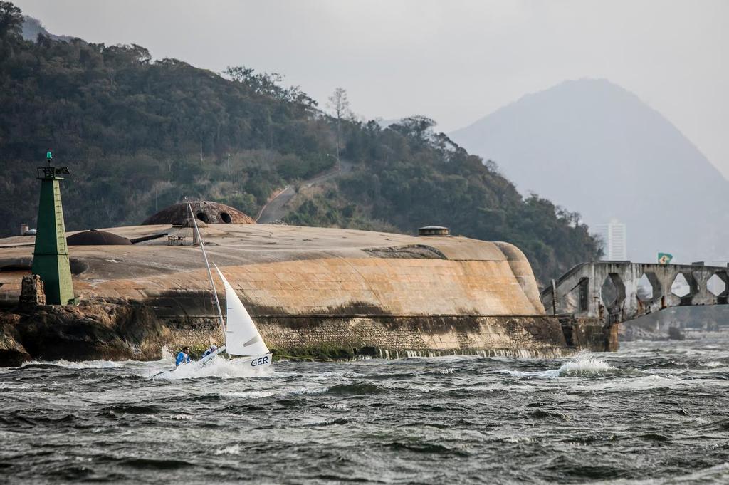 A 470 tows through the channel at entrance to Guanabara Bay after the 49er and 470 fleets were hit by a big squall just after the finish of the final 49er race on Day 8 photo copyright Sailing Energy / World Sailing taken at  and featuring the  class