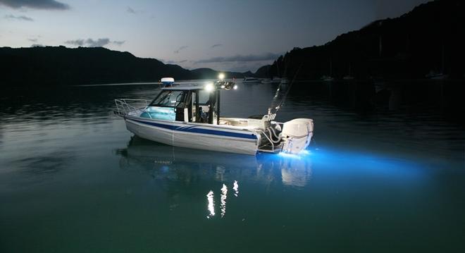 12 meter powerboat anchored at night lights