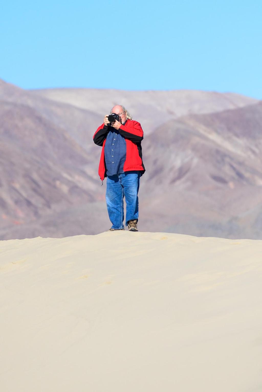 Eureka Valley Sand Dunes and Death Valley (USA, CA) December 2013. Photographer Bob Grieser hikes up a huge Sand Dune.<br />
The Eureka Valley Sand Dunes are located in the southern part of Eureka Valley, in northern Inyo County in eastern California, in the southwestern United States. Although covering an area of only 3 square miles (8 km?), the dunes rise approximately 680 feet (207 m) above the surrounding valley floor, making them one of the highest dune fields in North America.Eureka Valley is a  © Paul Todd www.outsideimages.com