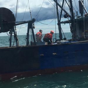 Two crew members from Coast Guard Cutter Oak battle a fire aboard the fishing vessel Juniper after their engine room caught fire in Nantucket Sound on May 11, 2017. The captain reported the fire over Ch. 16 at about 8:50 a.m., no injuries were reported photo copyright U.S. Coast Guard taken at  and featuring the  class