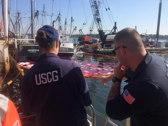 Coast Guard Petty Officer 1st Class Michael Schneider and Petty Officer 2nd Class Shannon Young oversee the fuel spill clean up efforts in New Bedford Harbor Wednesday, Aug. 16, 2017. The fishing vessel Challenge sank at the pier and held about 7,000 gallons of fuel.  © Lt. Lynn Schrayshuen